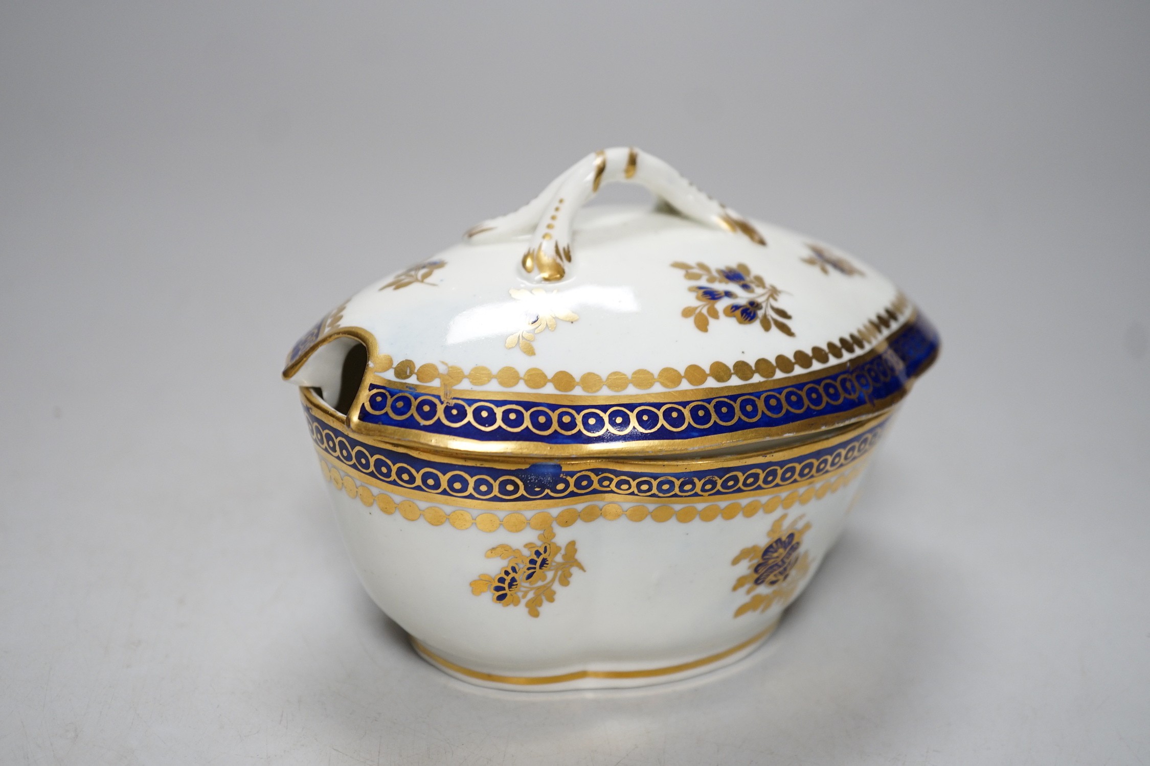 An 18th century Caughley tureen cover and stand with blue and gilt decoration, stand mis-fired to border, S mark to stand and base. 15cm wide